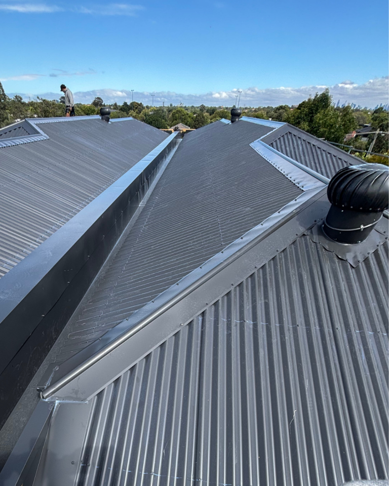 Close-up of a Klip-Lok metal roofing installation showing ridge and flashing work completed by Pitch Perfect Roof Plumbing.