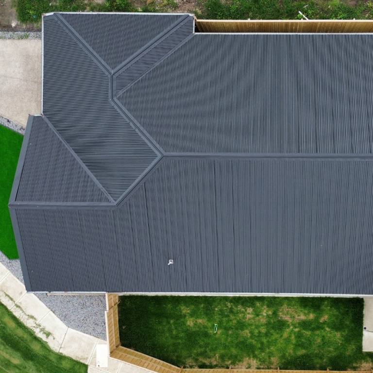 Aerial overhead view of a large residential property showcasing a complex dark metal roof installed by Pitch Perfect Roof Plumbing in Melbourne.