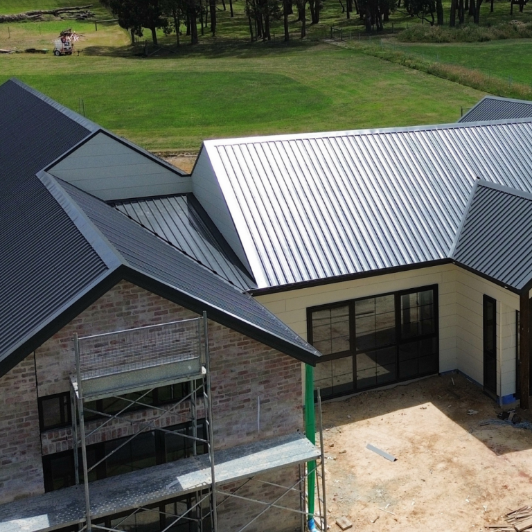 Close-up view of a Klip-Lok metal roof installation on a brick home completed by Pitch Perfect Roof Plumbing.