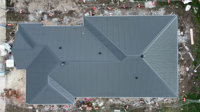 Aerial top-down view of a large residential home featuring a newly installed dark metal roof by Pitch Perfect Roof Plumbing in Melbourne.