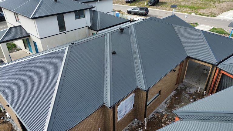 Aerial view of two new residential builds featuring dark metal roofing installed with precision by Pitch Perfect Roof Plumbing.