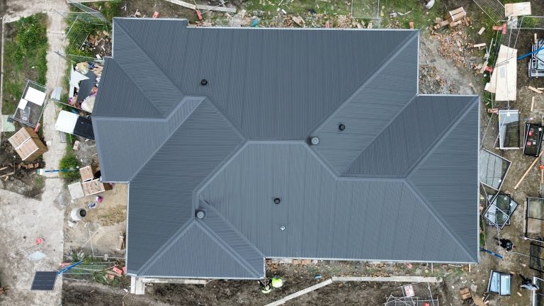 Overhead image of a detailed multi-pitched metal roof installed on a residential property by Pitch Perfect Roof Plumbing.