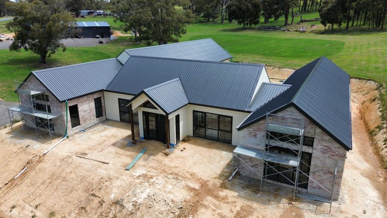 Aerial view of a newly constructed home with a completed metal roof installation by Pitch Perfect Roof Plumbing in Melbourne.